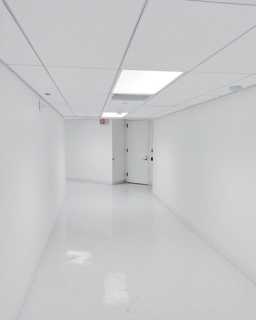 Bright uncluttered institutional corridor with plain walls and doors