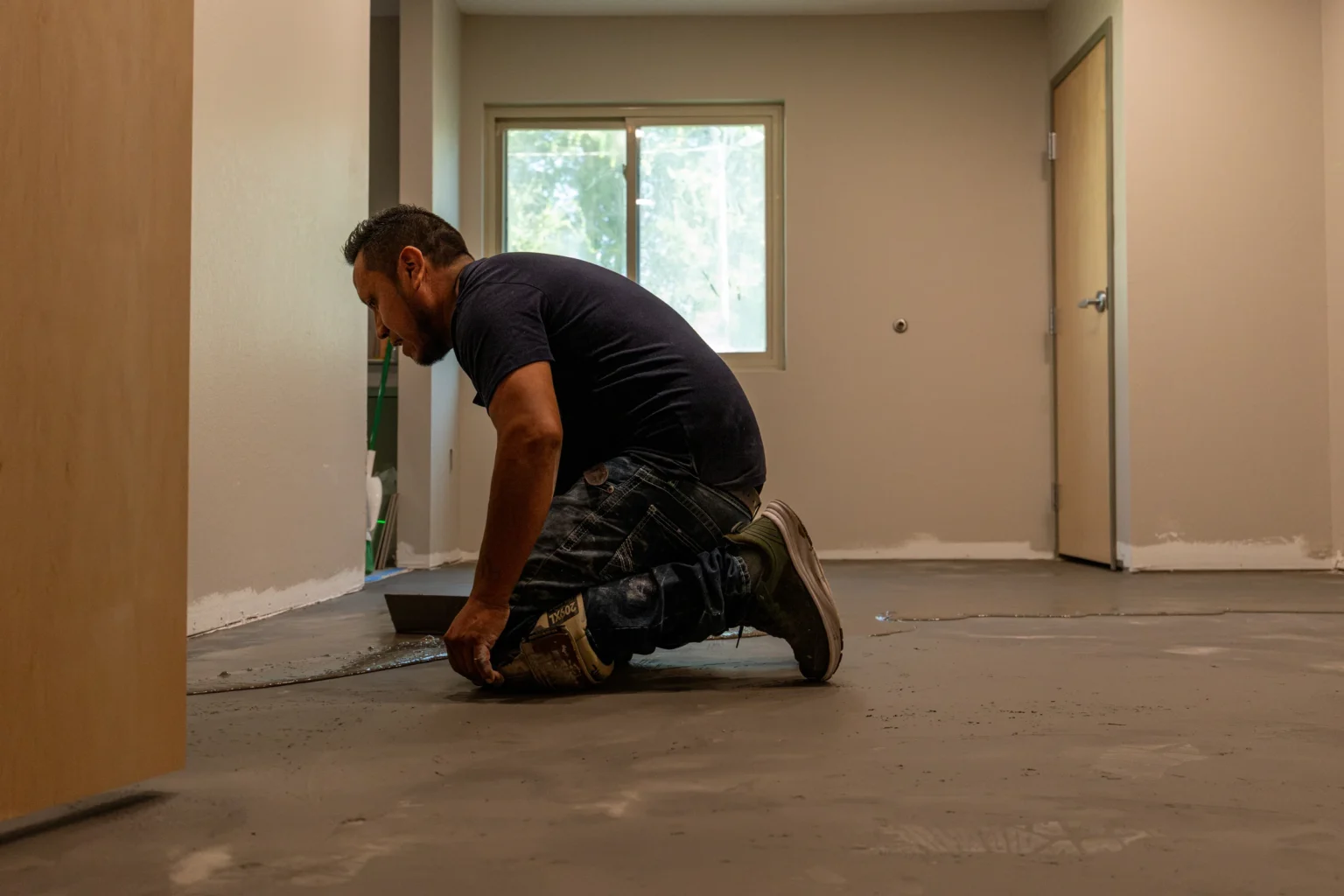 Installer preparing the floor inside a room under renovation