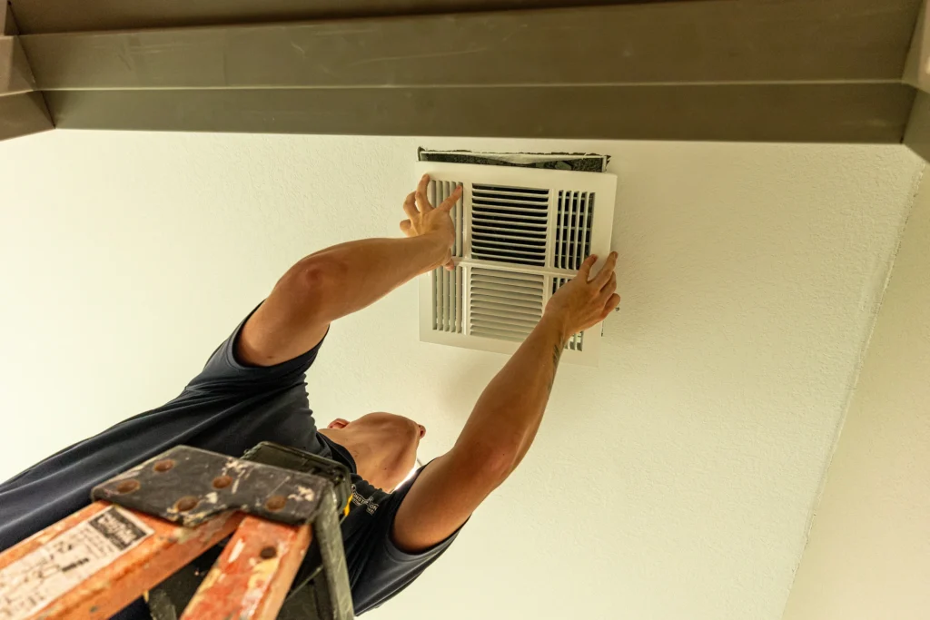 Crew member fitting a ceiling ventilation grille