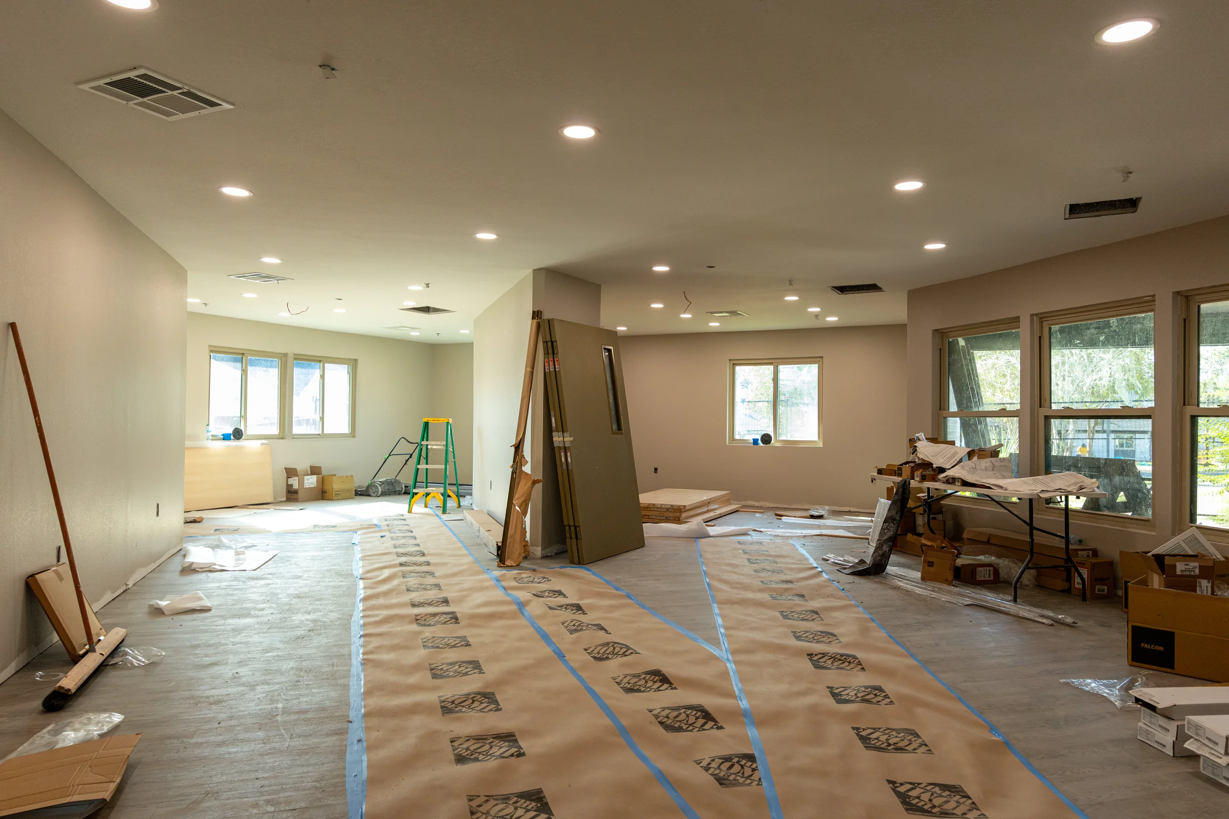 Interior renovation work area with protected flooring and staged materials