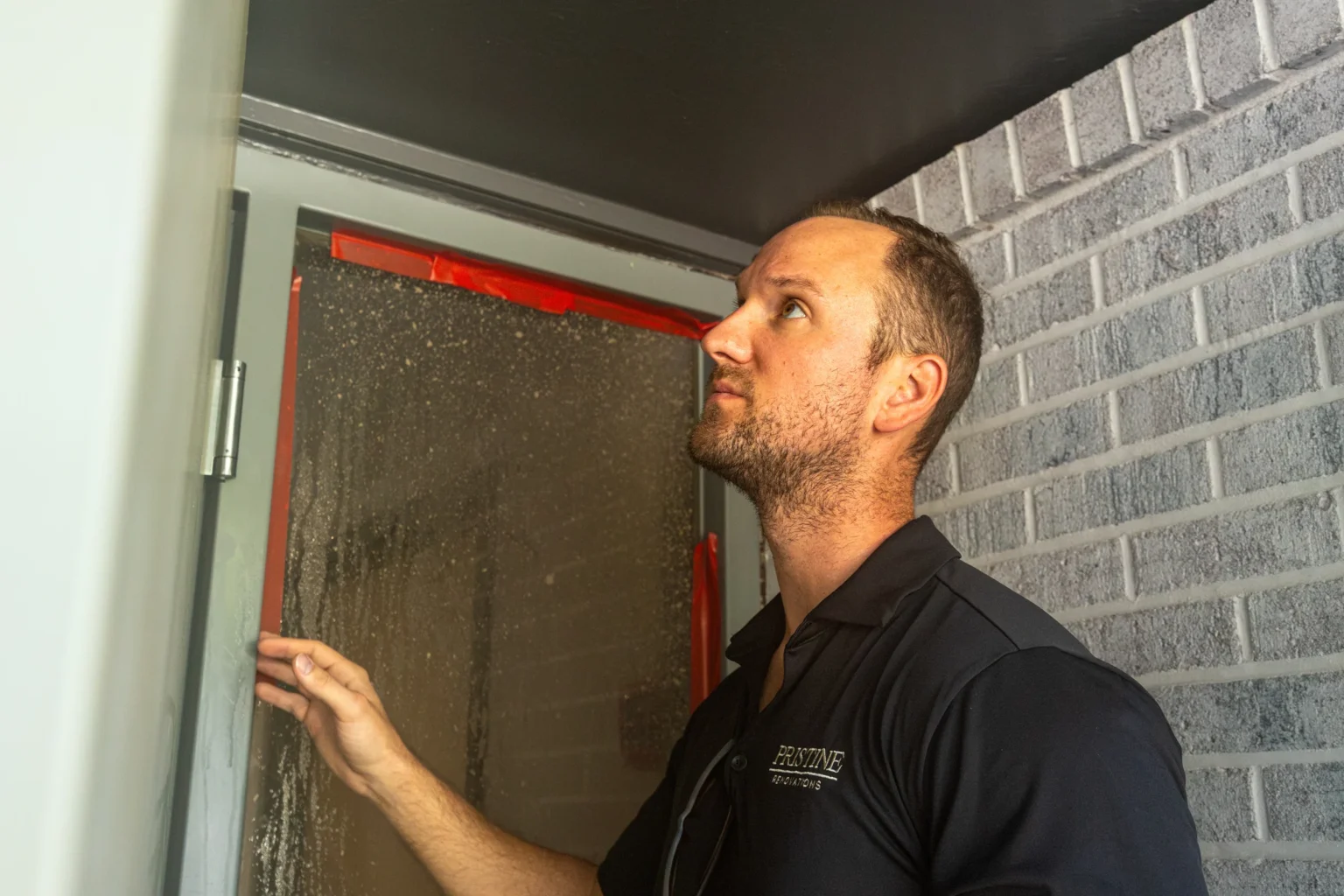 Pristine team member inspecting a door frame during renovation