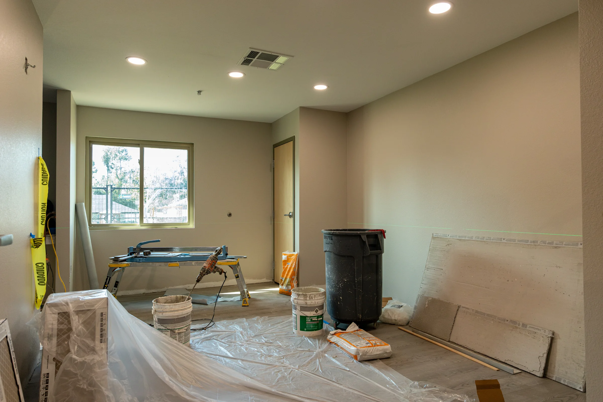 Protected renovation work area with tools and materials staged on covered flooring